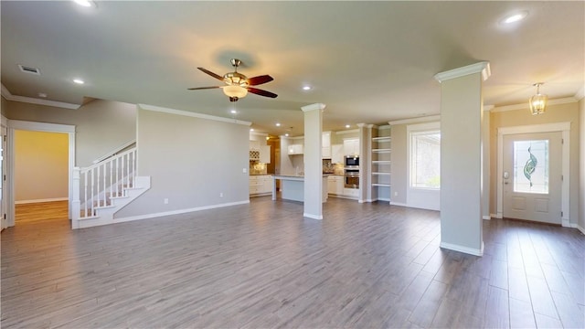 1218 Bradley St, Centerton, AR 72719 - unfurnished living room featuring crown molding, a ceiling fan, dark wood-style flooring, recessed lighting, and stairway
