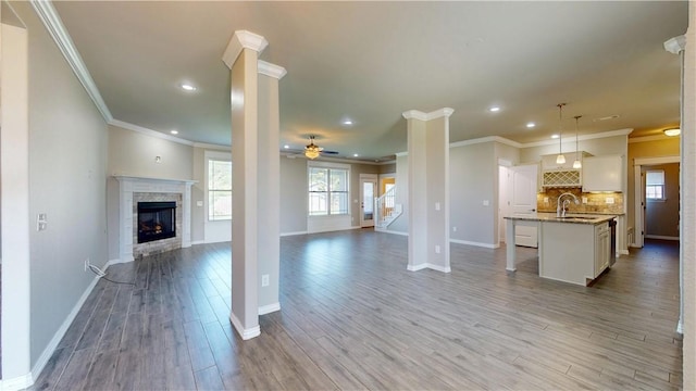 1218 Bradley St, Centerton, AR 72719 - unfurnished living room with ornamental molding, light wood finished floors, recessed lighting, a ceiling fan, and a fireplace