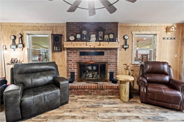 89 Creekview Rd, Harrison, AR 72601 - living room featuring wooden walls, wood finished floors, ceiling fan, and a brick fireplace