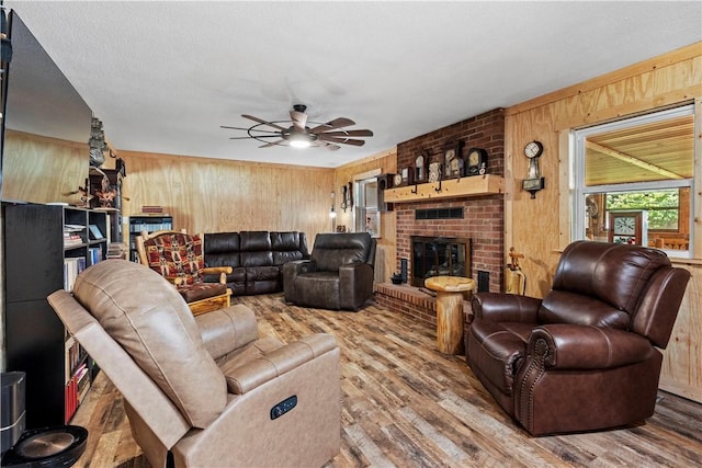 89 Creekview Rd, Harrison, AR 72601 - living room featuring wood walls, wood finished floors, ceiling fan, and a brick fireplace