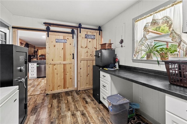 89 Creekview Rd, Harrison, AR 72601 - kitchen with stainless steel dishwasher, a barn door, freestanding refrigerator, dark wood-type flooring, and dark countertops