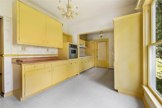 625 W College Ave, Harrison, AR 72601 - kitchen with wallpapered walls, cream cabinetry, a chandelier, and light floors