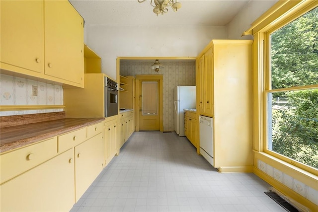 625 W College Ave, Harrison, AR 72601 - kitchen with wallpapered walls, healthy amount of natural light, light floors, white appliances, and light countertops