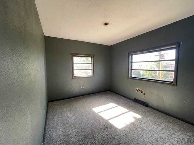 1726 W 12th St, Pueblo, CO 81003 - unfurnished room featuring a healthy amount of sunlight, carpet floors, a textured wall, and visible vents