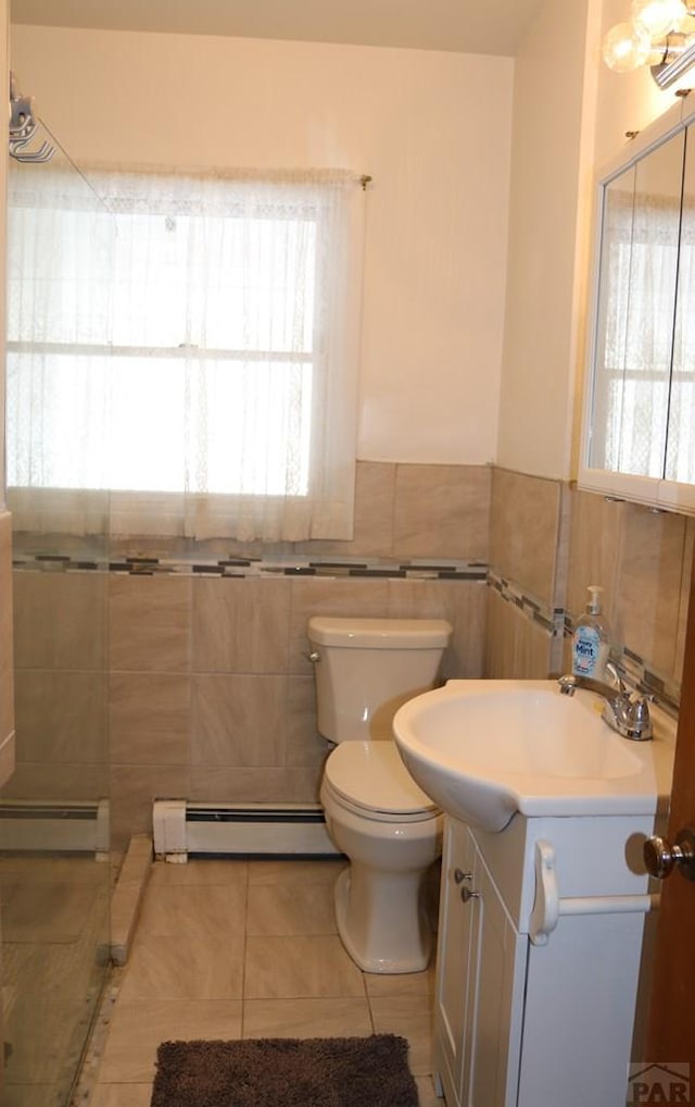 bathroom featuring tile patterned floors, a baseboard radiator, tile walls, and vanity