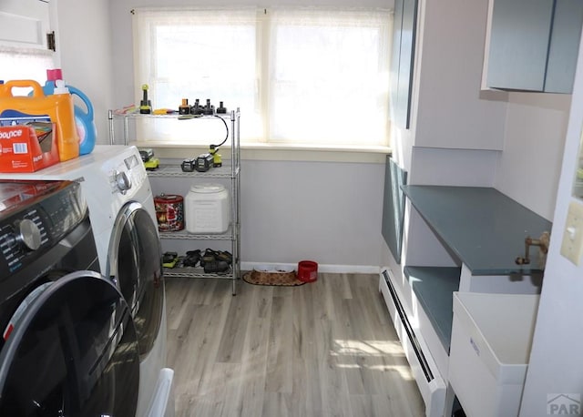 laundry room with a baseboard radiator, laundry area, separate washer and dryer, baseboards, and light wood-type flooring