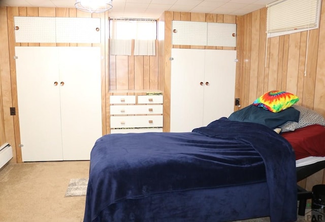 bedroom featuring a closet, light carpet, and wooden walls