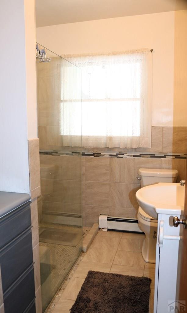 full bathroom featuring tiled shower, a baseboard radiator, vanity, and tile patterned floors