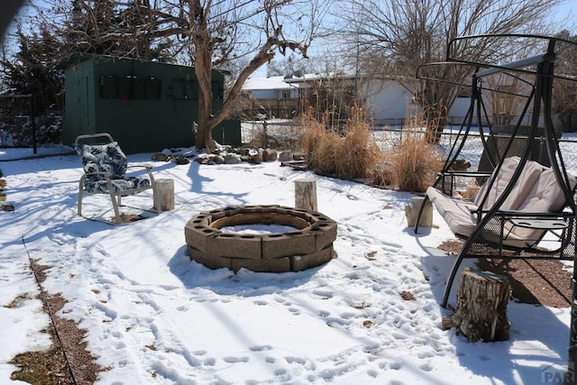 snowy yard featuring an outdoor fire pit