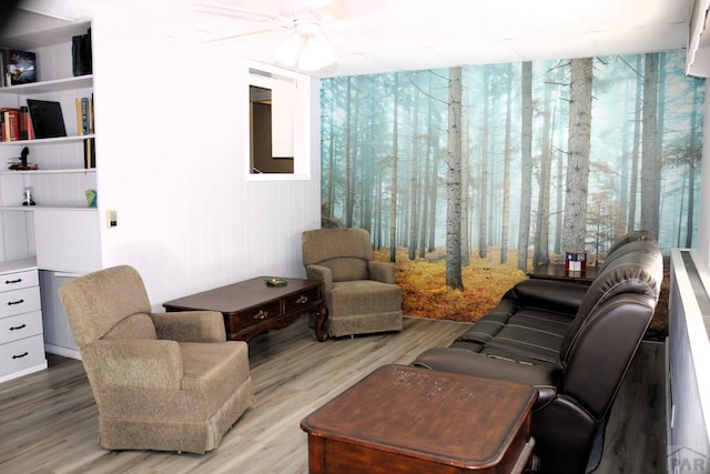 sitting room with a ceiling fan and light wood-style flooring