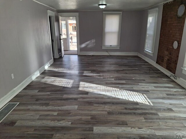 unfurnished room with baseboards and dark wood finished floors