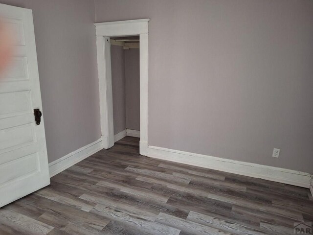 unfurnished bedroom with baseboards and wood finished floors