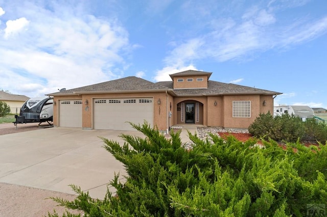 1037 W Desert Sage Dr, Pueblo West, CO 81007 - view of front of house featuring driveway, a garage, stucco siding, and roof with shingles