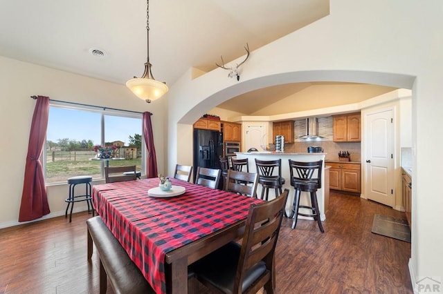 1037 W Desert Sage Dr, Pueblo West, CO 81007 - dining area featuring arched walkways, lofted ceiling, and dark wood finished floors