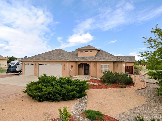1037 W Desert Sage Dr, Pueblo West, CO 81007 - view of front of home featuring stucco siding, an attached garage, concrete driveway, and a shingled roof