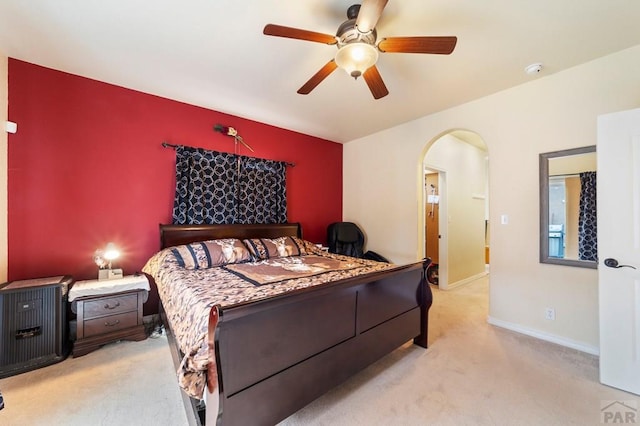 1037 W Desert Sage Dr, Pueblo West, CO 81007 - bedroom with arched walkways, light carpet, a ceiling fan, and baseboards