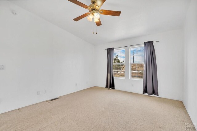 unfurnished room featuring carpet, visible vents, and a ceiling fan