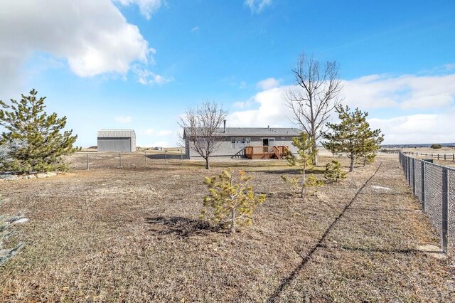 rear view of property featuring a rural view and fence