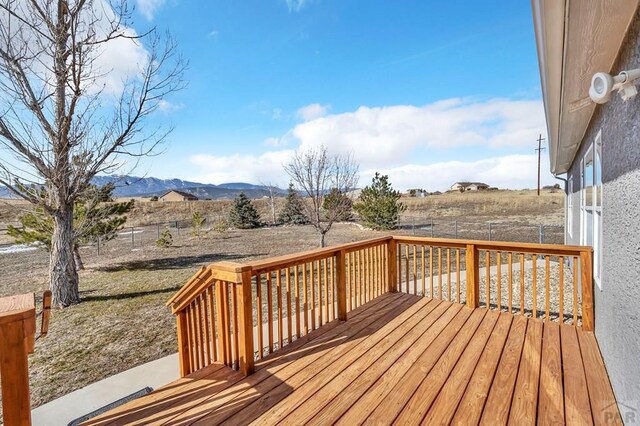 deck with a fenced backyard and a mountain view