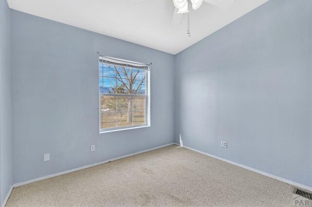 unfurnished room featuring carpet floors, baseboards, visible vents, and ceiling fan