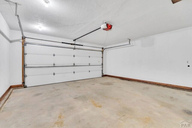 garage featuring a garage door opener and baseboards