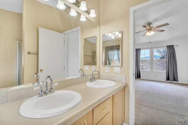 bathroom featuring ceiling fan, a sink, and double vanity