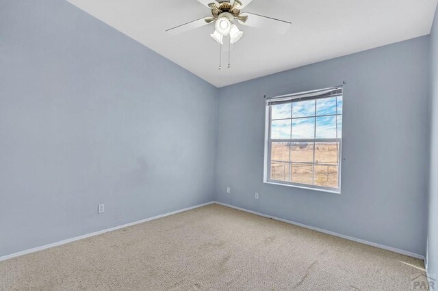 carpeted empty room with a ceiling fan and baseboards