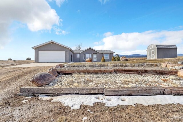 view of front of property featuring an outbuilding, stucco siding, a storage unit, concrete driveway, and a garage