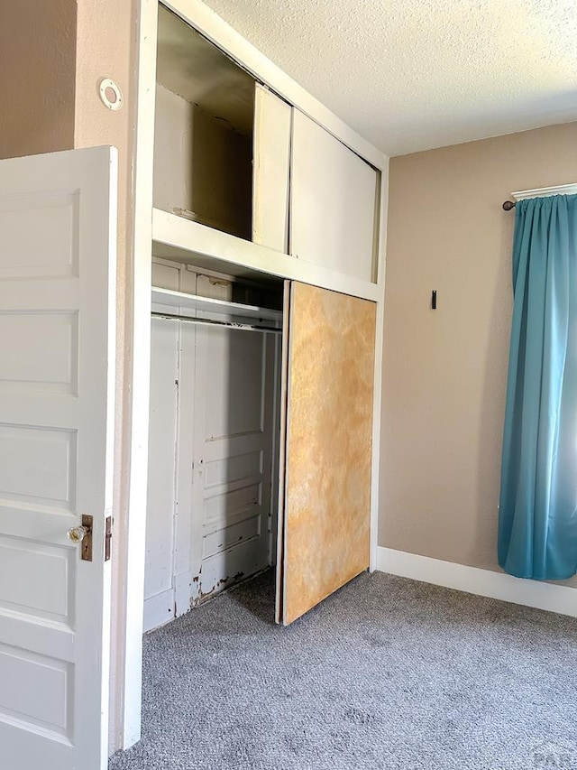 1202 Belleview Ave, La Junta, CO 81050 - unfurnished bedroom featuring carpet floors, a closet, and a textured ceiling