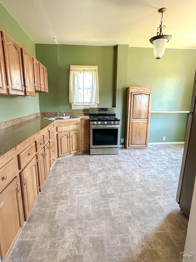 1202 Belleview Ave, La Junta, CO 81050 - kitchen with gas range, light stone finish flooring, hanging light fixtures, and light brown cabinets