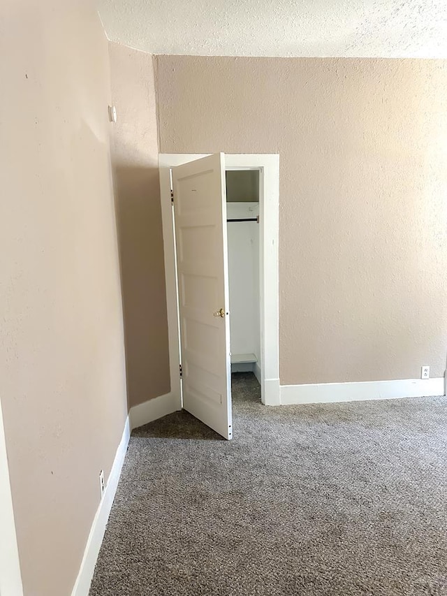 1202 Belleview Ave, La Junta, CO 81050 - unfurnished bedroom with carpet flooring, a textured wall, and a closet