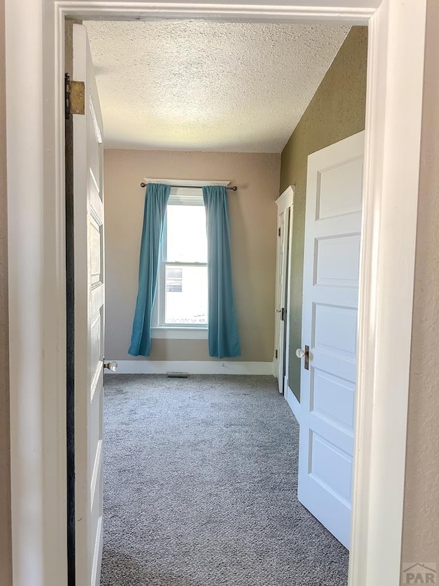 1202 Belleview Ave, La Junta, CO 81050 - empty room featuring a textured ceiling and carpet flooring