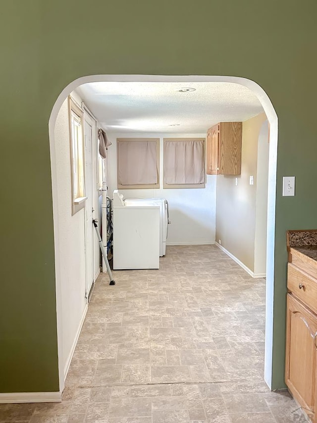 1202 Belleview Ave, La Junta, CO 81050 - laundry area featuring cabinet space, arched walkways, stone finish flooring, and washer and dryer