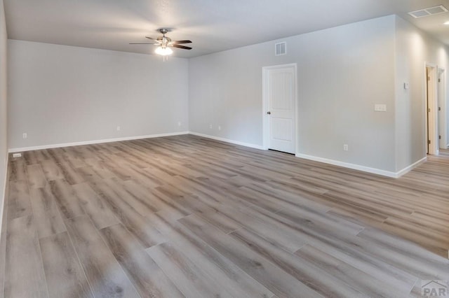 unfurnished room featuring light wood-style flooring, visible vents, and baseboards