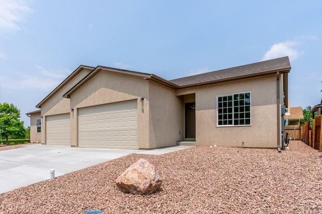 single story home with a garage, driveway, fence, and stucco siding