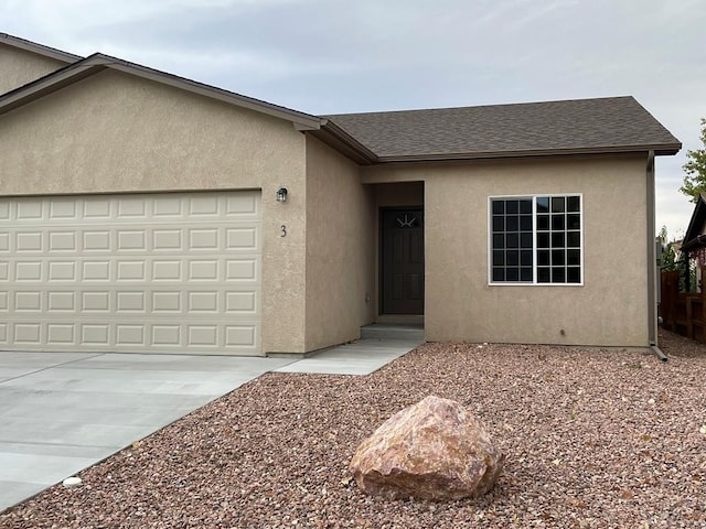 single story home featuring roof with shingles, driveway, an attached garage, and stucco siding