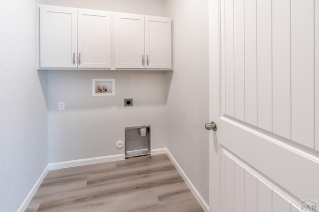 washroom featuring washer hookup, cabinet space, electric dryer hookup, and baseboards