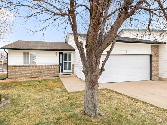 single story home with brick siding, a shingled roof, an attached garage, driveway, and a front lawn