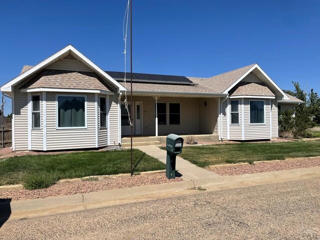600 W 5th St, Ordway, CO 81063 - ranch-style home featuring solar panels, a front lawn, and roof with shingles