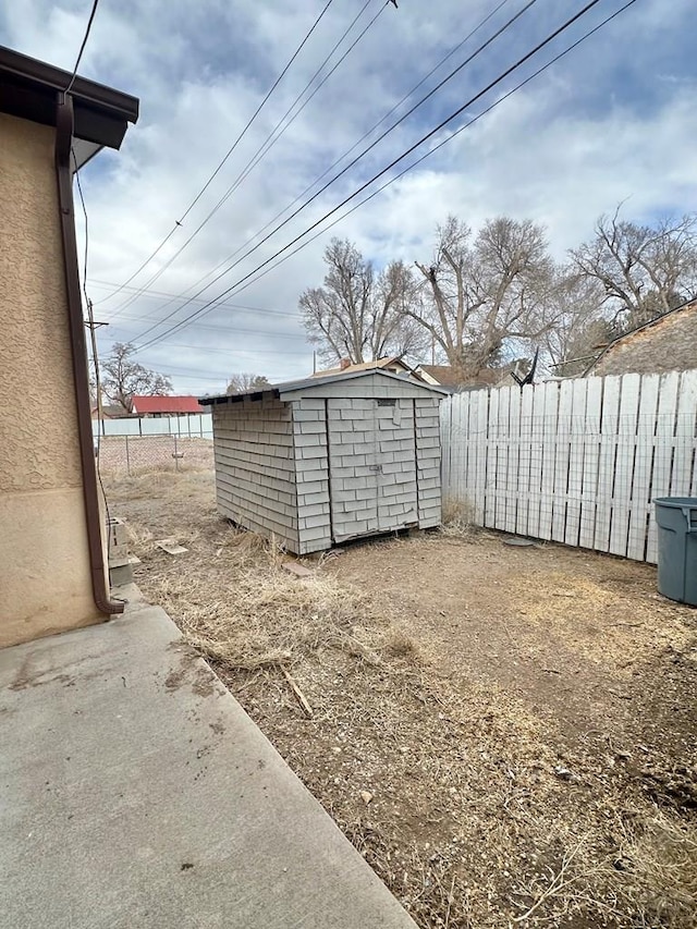 view of yard with a shed, an outdoor structure, and fence