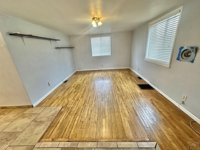 interior space featuring wood-type flooring, visible vents, and baseboards