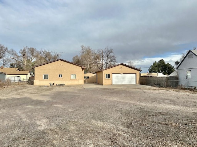 exterior space featuring a garage, fence, and an outdoor structure