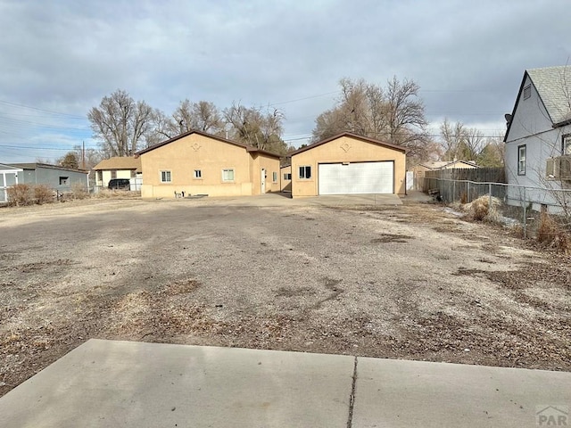 exterior space with a detached garage and fence