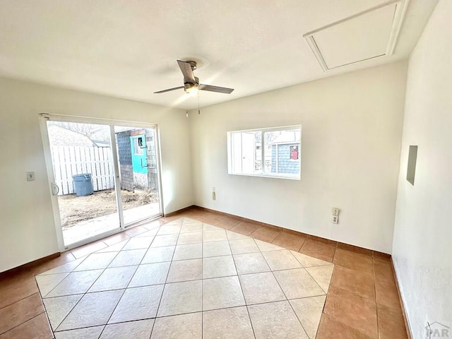 empty room with a wealth of natural light, ceiling fan, baseboards, and light tile patterned floors