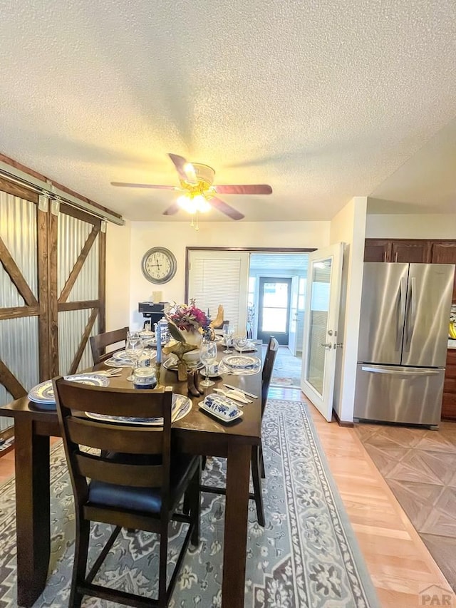 dining area with parquet floors, a textured ceiling, and a ceiling fan