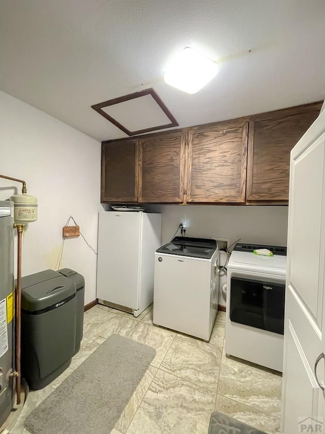 washroom with washing machine and dryer, marble finish floor, water heater, and cabinet space