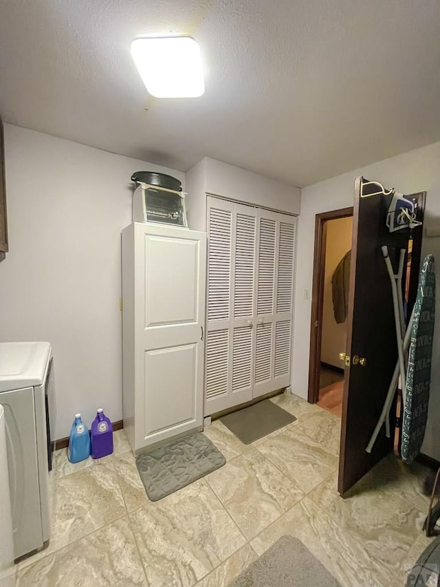 washroom featuring a textured ceiling, laundry area, and washer / clothes dryer