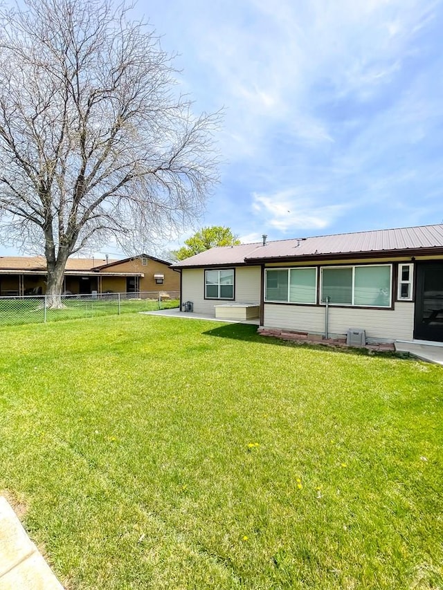 back of property with fence and a yard