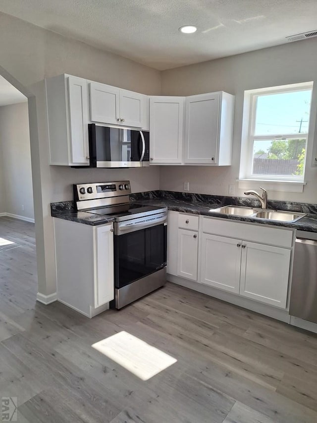 211 W Maplewood, Walsh, CO 81090 - kitchen with stainless steel appliances, a sink, light wood-style floors, dark countertops, and recessed lighting