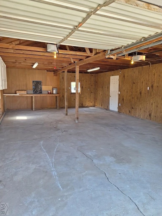 211 W Maplewood, Walsh, CO 81090 - garage featuring a garage door opener and wood walls